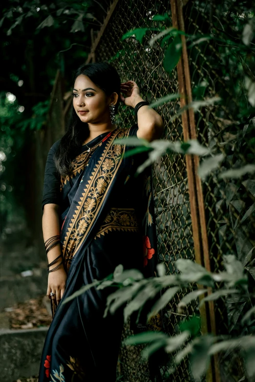 a beautiful young woman leaning against a fence