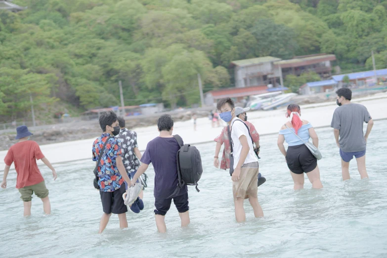 several people are wading through the water together