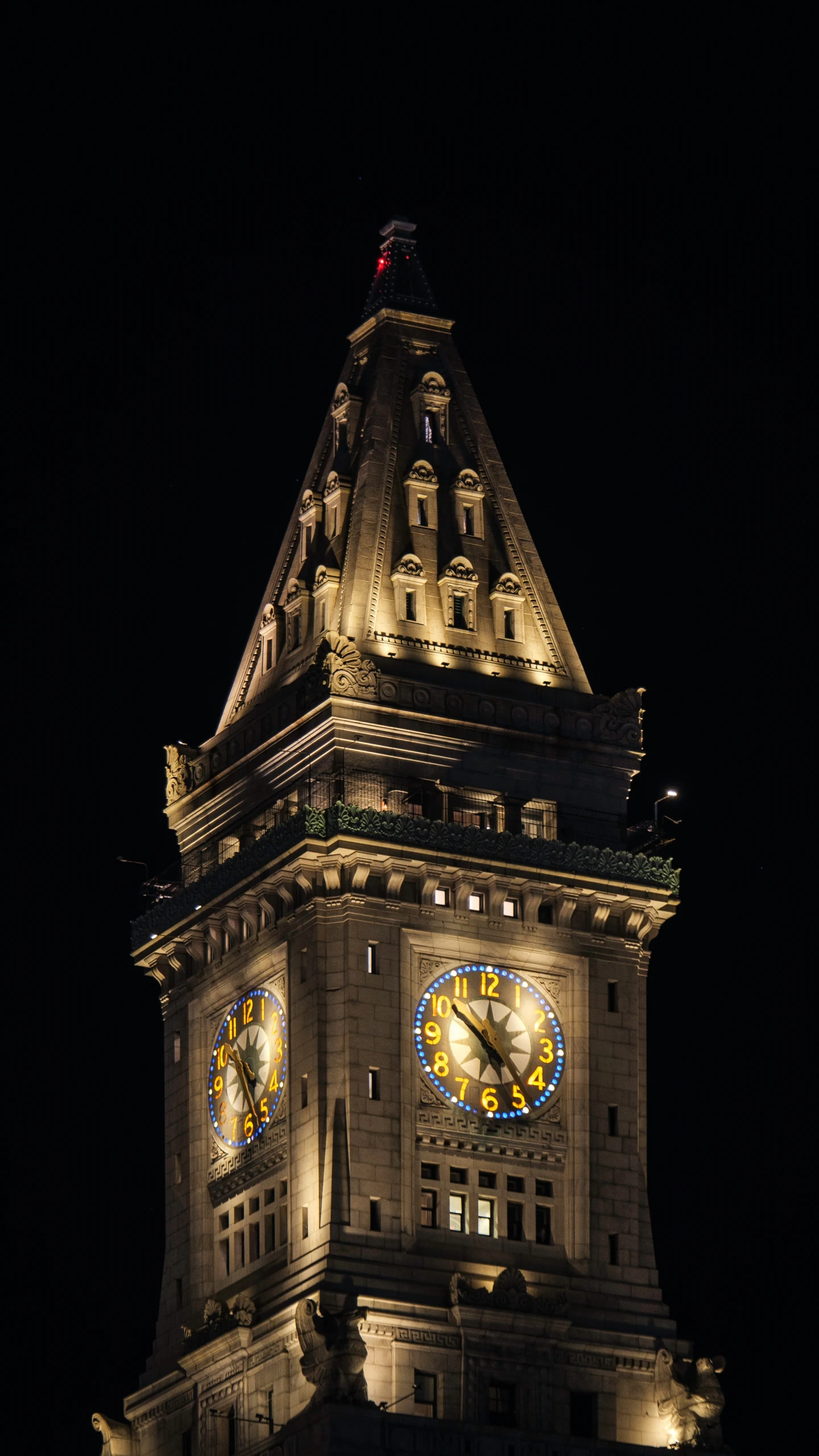 the clock tower is illuminated with a full moon