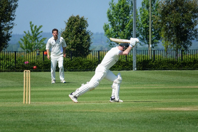 a cricket player lunges to avoid a ball
