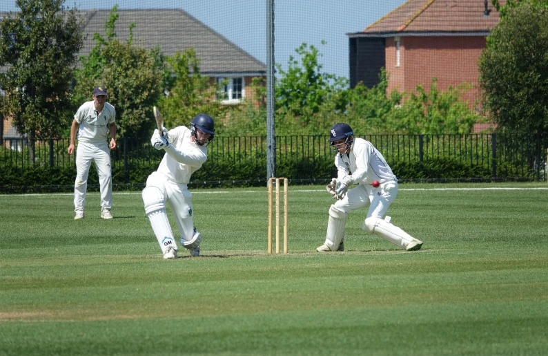 two cricket players in white playing a game