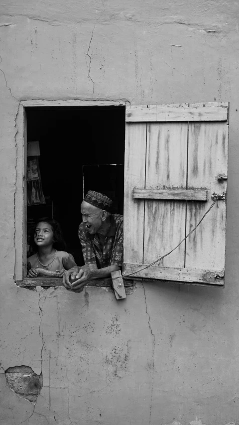 a person standing next to a child in the window