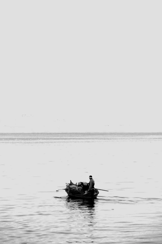 a man rows a small boat across the water