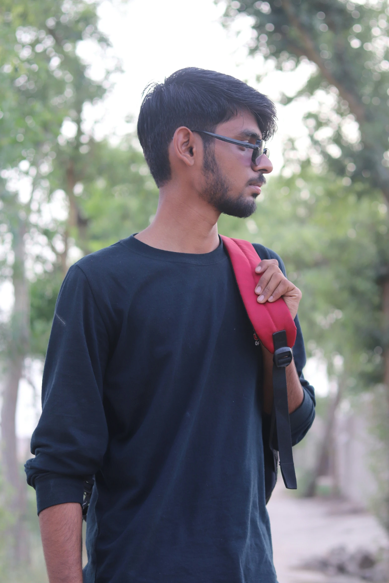 man in black shirt holding pink bag in outdoor area