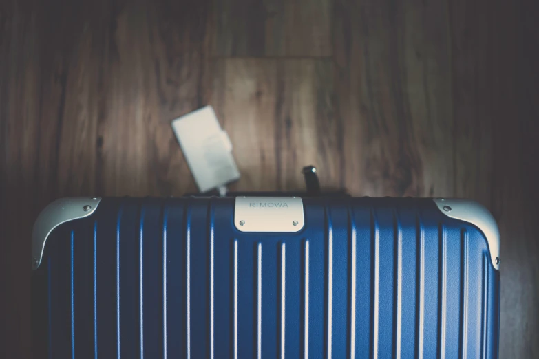 a striped suitcase sitting in front of a wooden background