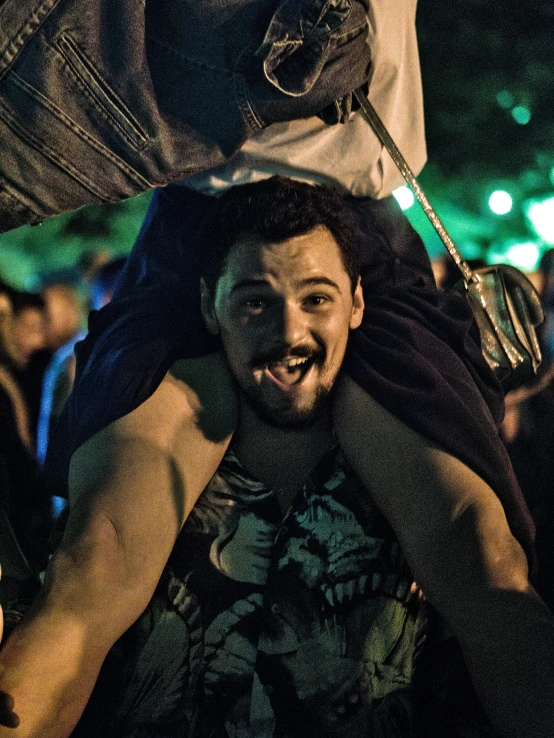 a man sitting on top of a woman and smiling at the camera