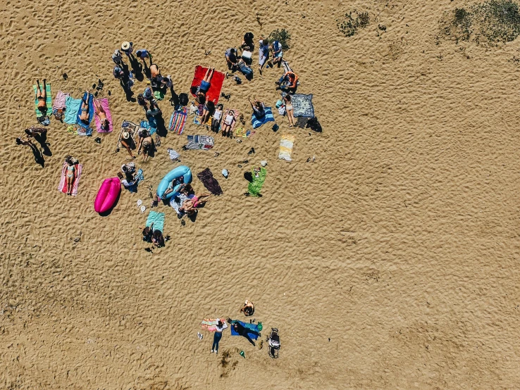 an aerial view of people standing on the beach