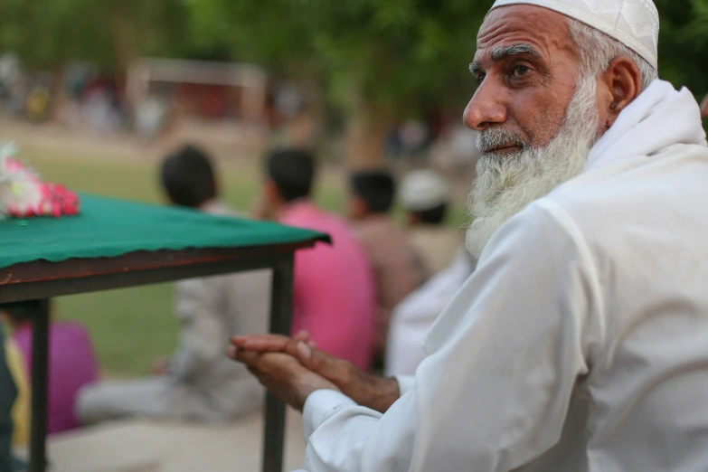 a man with a long white beard sitting outside