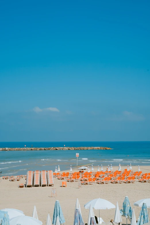 a white beach with chairs and umbrellas is shown