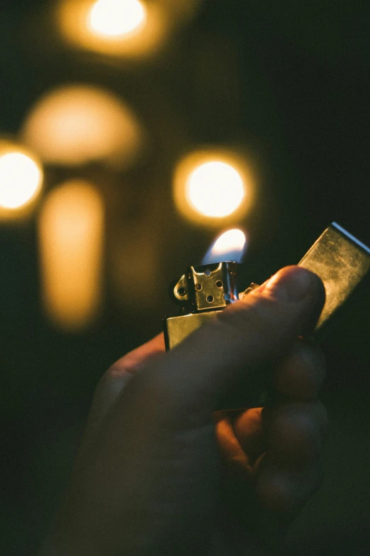 closeup of person lighting the lighter on the lighter in front of a building