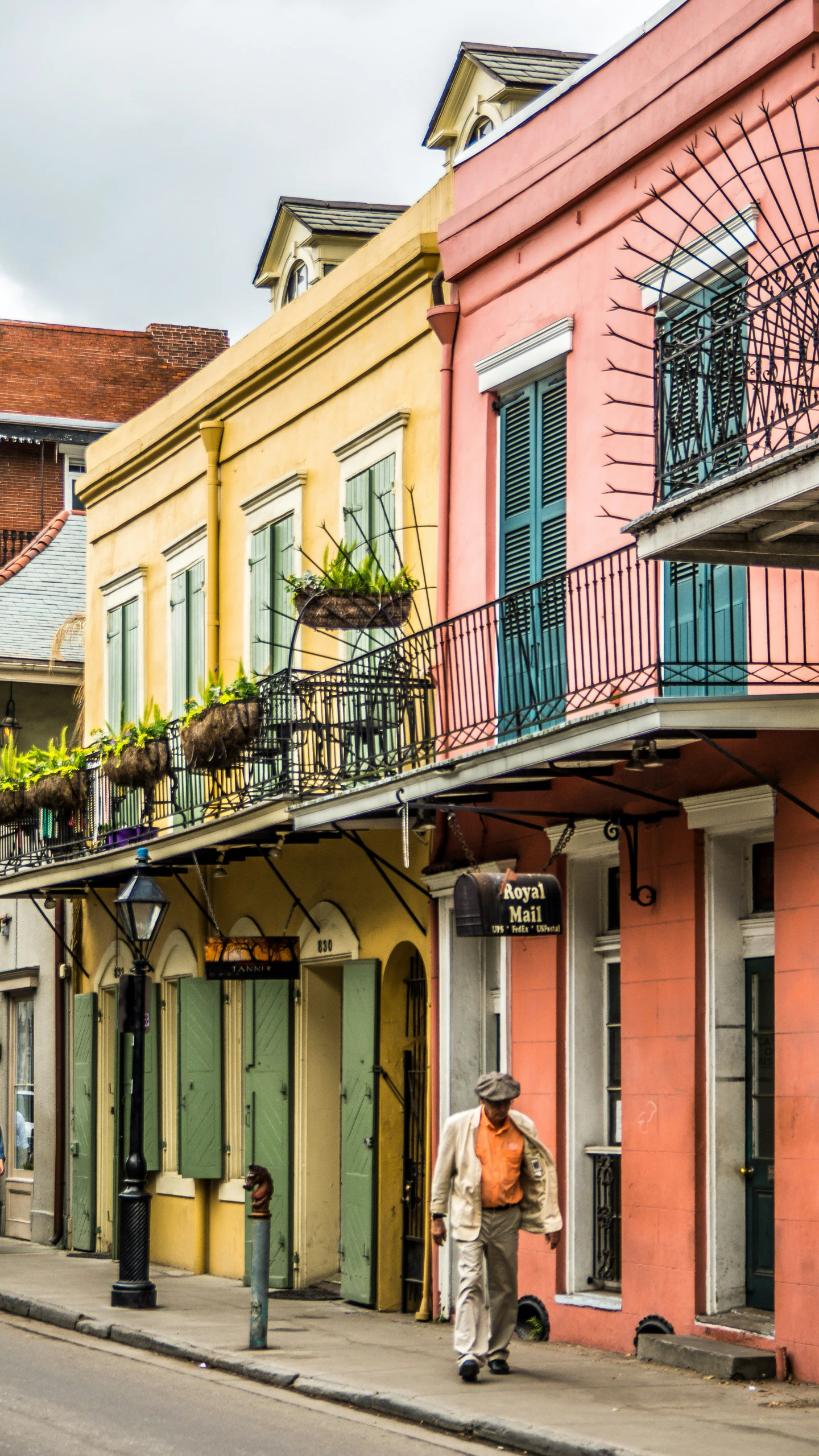 a man riding a skateboard on a street past colorful buildings