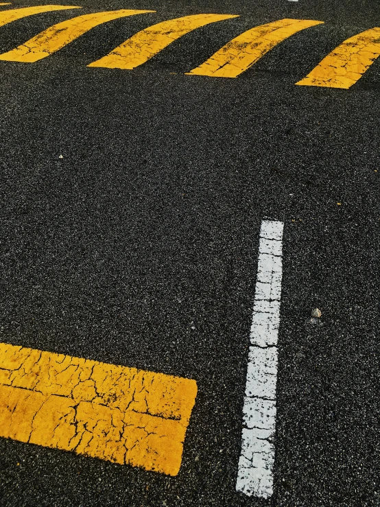 a black and yellow crossing in the middle of a road