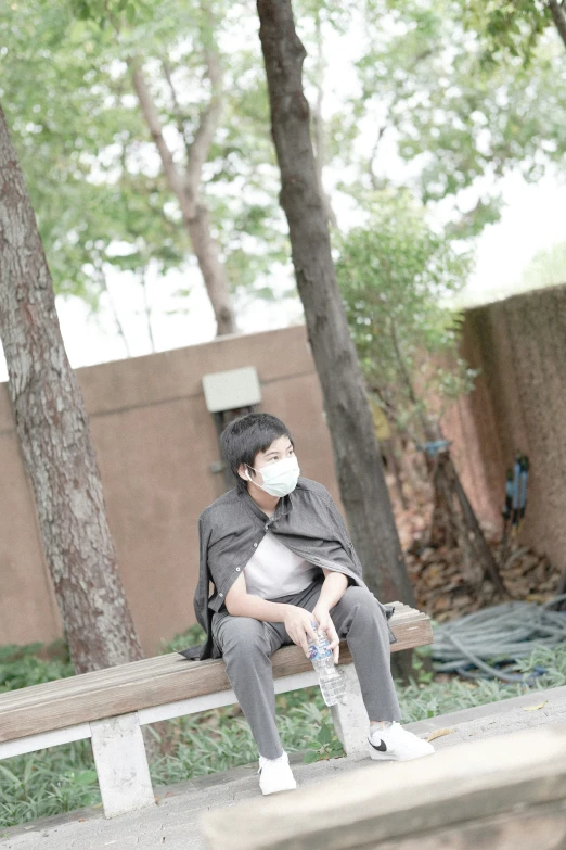 a person in a mask sitting on a bench