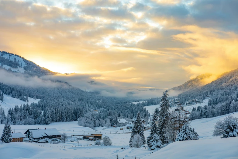 a sunset in a snowy mountain town covered with snow