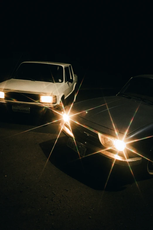 two trucks are illuminated in the dark on the road