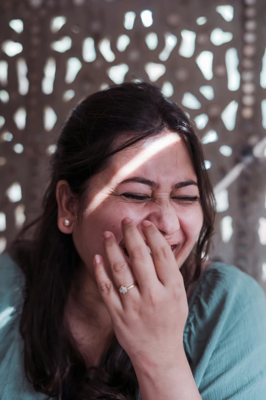 a woman laughing and using her cell phone