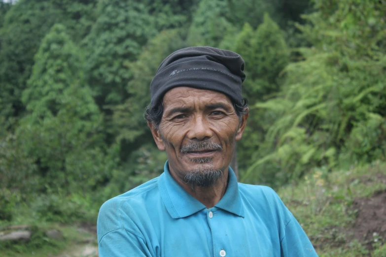 a man is sitting in front of some trees