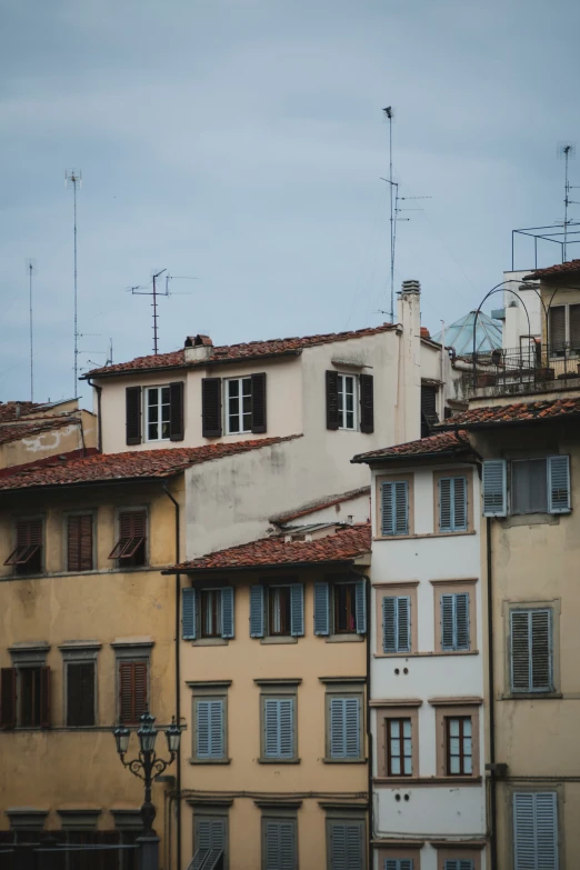 multiple buildings with chimneys and windows against a cloudy sky