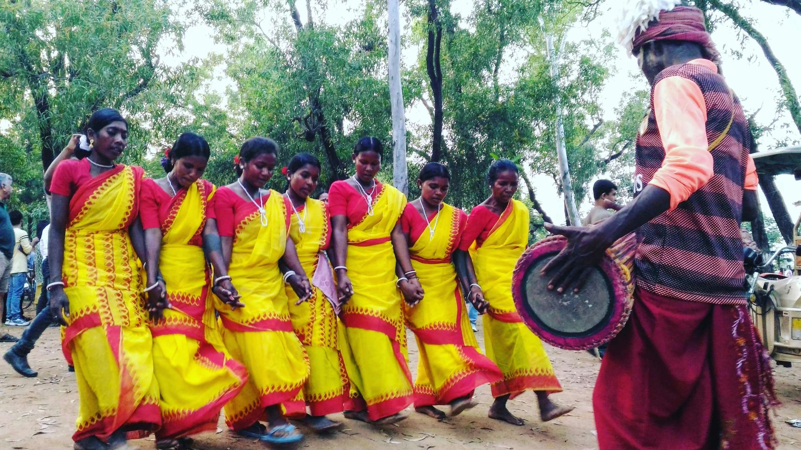 woman dressed in traditional sari walking past a large group