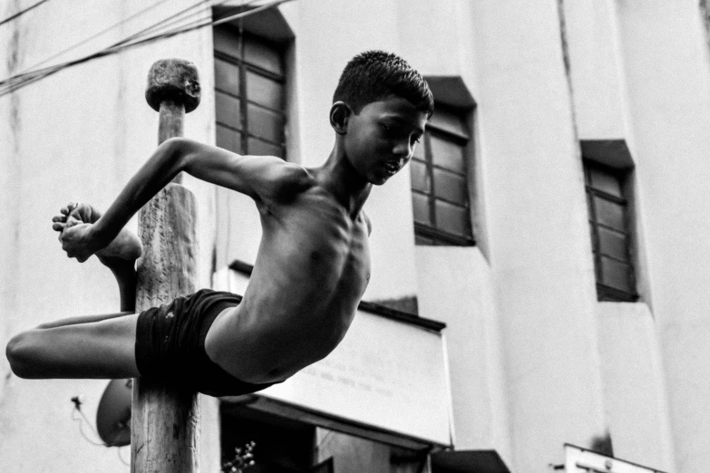 a shirtless man hanging from a street light