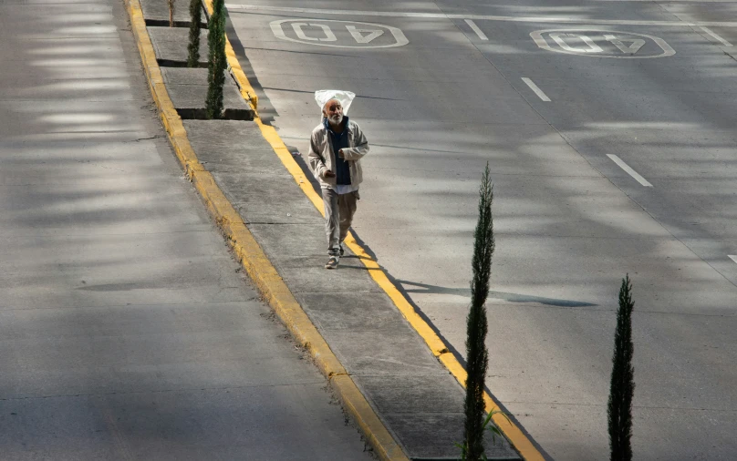 a woman carrying an umbrella down a road