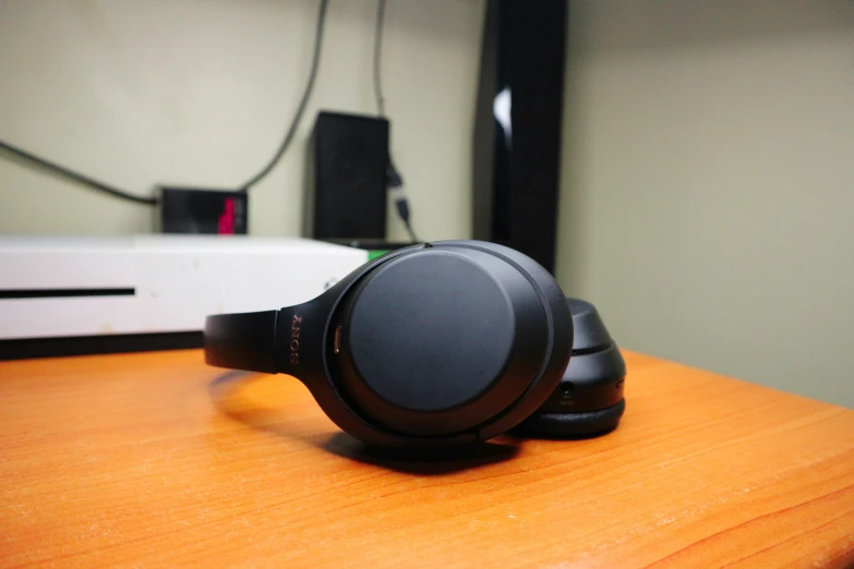 a black headphones sitting on a wooden table