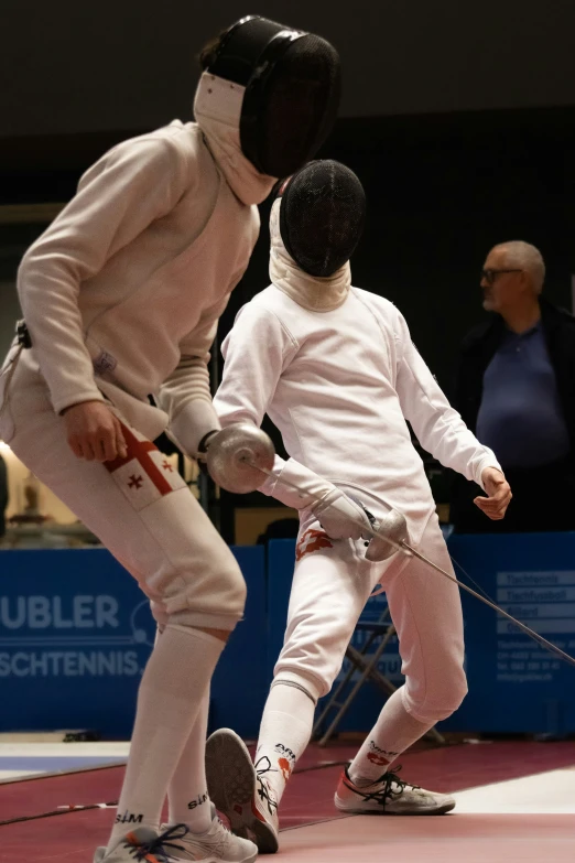 the two young children are practicing fencing together