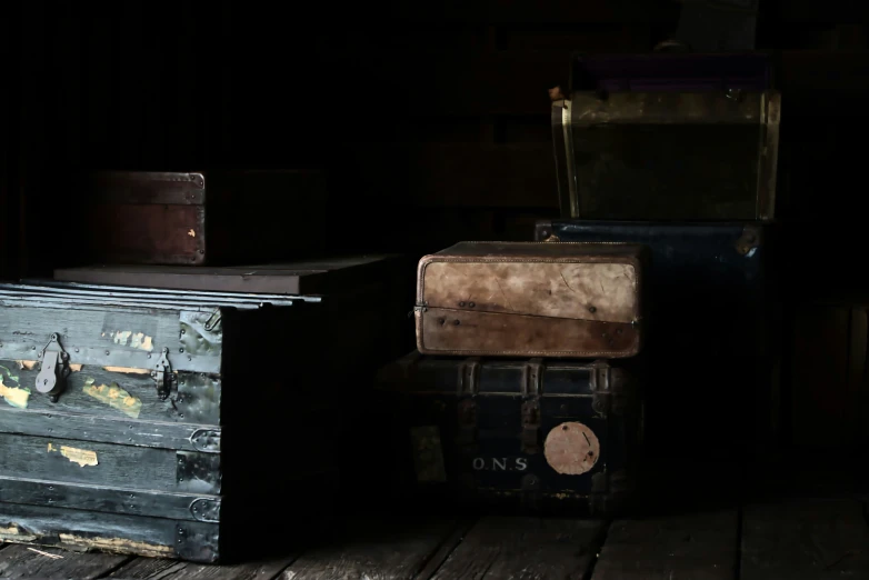 three old trunks are stacked on the floor