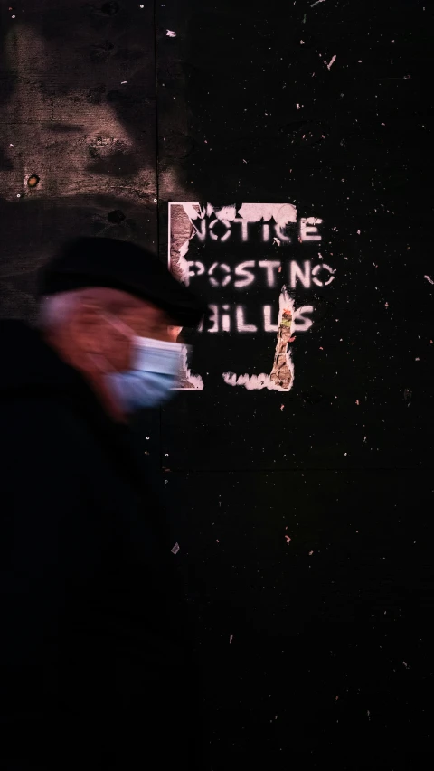 a man walks on the sidewalk in a dark alley