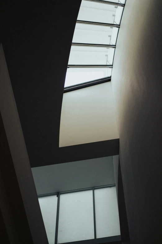 an upward view of a building with bright sunlight streaming through the windows