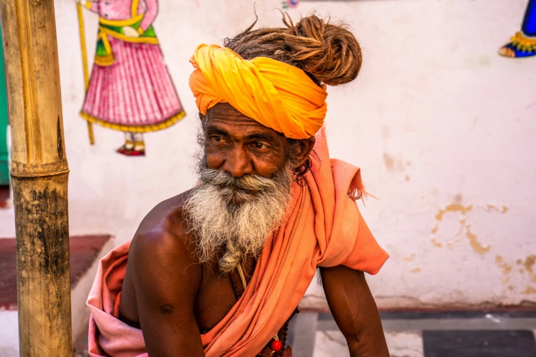 a man wearing a yellow turban and a big brown beard