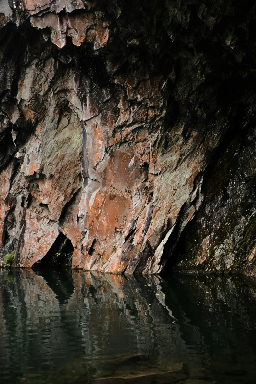 water under a rock formation and surrounding by a rock wall