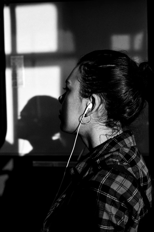 a woman standing in front of a mirror wearing ear buds