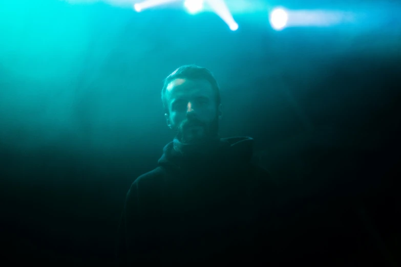a bearded man in front of a projection screen
