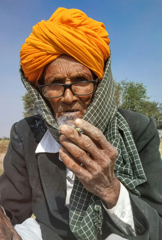 a man in turban holding soing up to his mouth