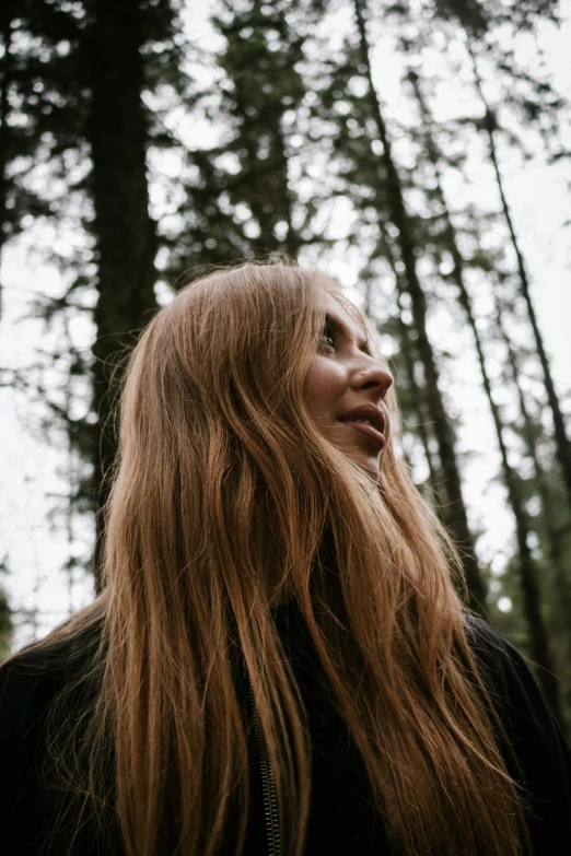 a woman standing in front of many trees