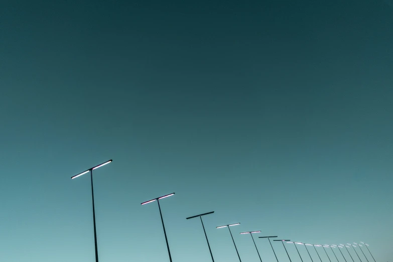 a row of lights on a bridge next to a body of water