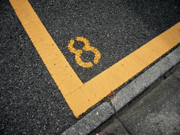 an yellow stripe painted on the asphalt that indicates six