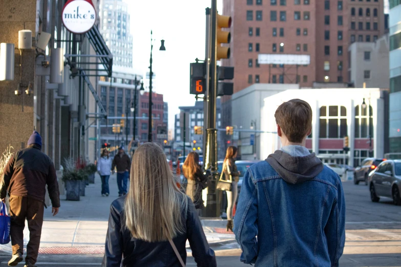 people are walking down the street and crossing the crosswalk