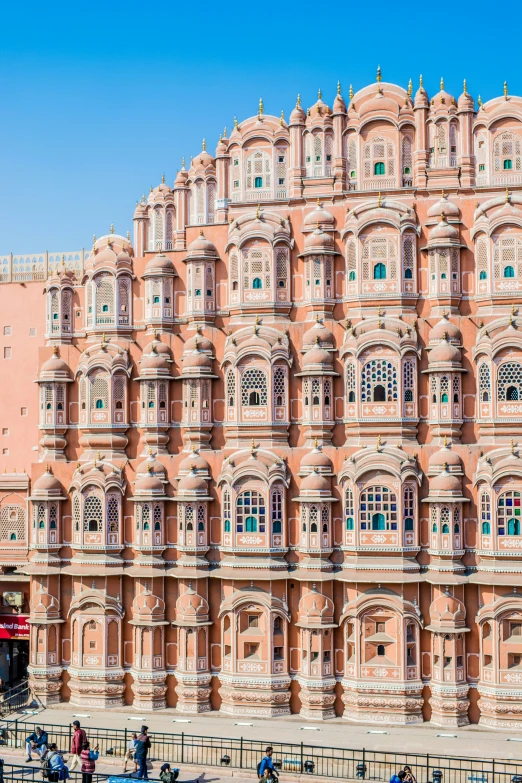 a big brick building with ornate windows and a red bus