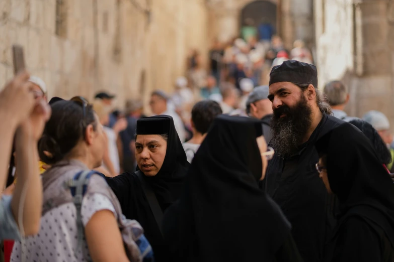 people walking in line with one woman wearing a black head covering