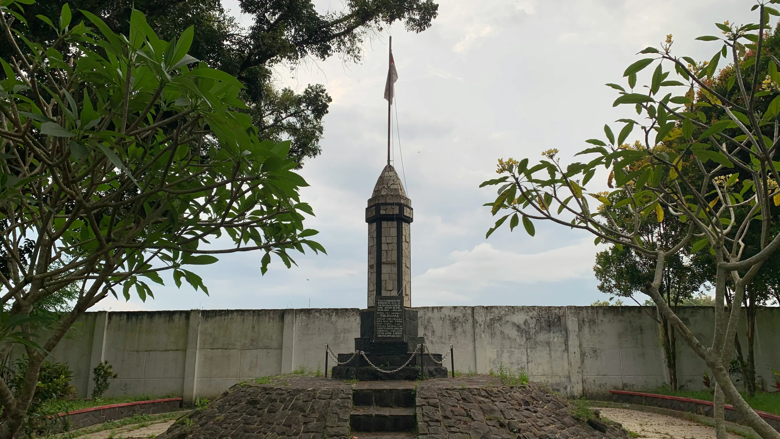 a tall tower with a small flag atop it