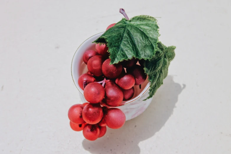 a bowl with small berries in it on a white table