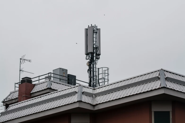 an antenna on top of a building with a bird sitting on the roof