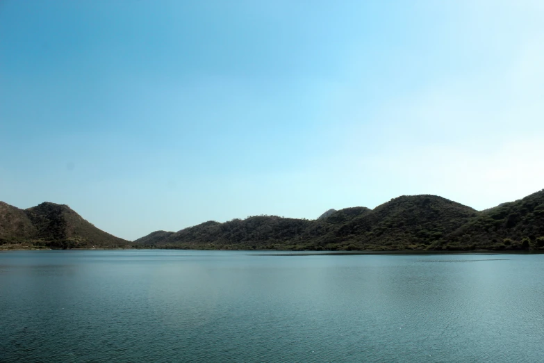 a lake and some mountains with a blue sky