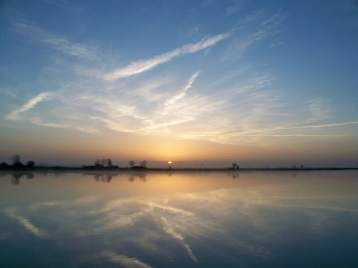 a body of water with some clouds in the sky