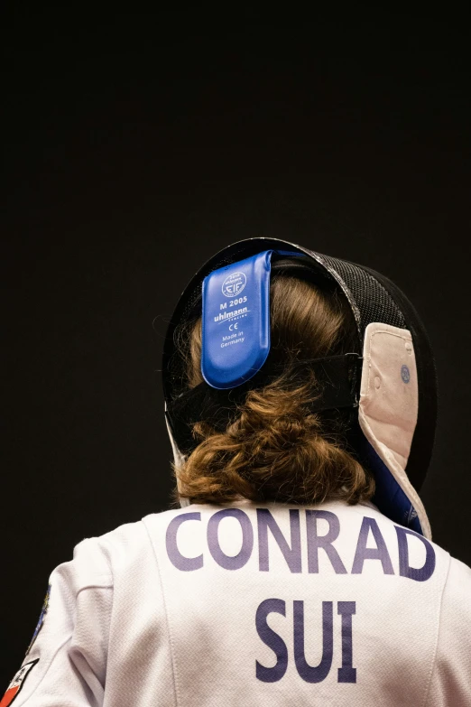 someone wearing a visor that has the word conrad sui in it