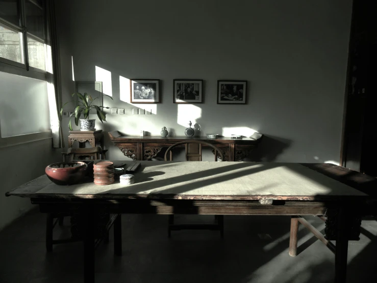 an old wooden table with vases and other objects sitting on it