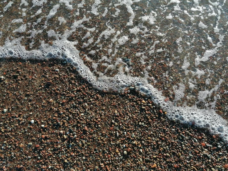 water flowing into the shore on top of sand