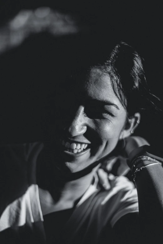 an young woman smiles brightly as she stands outside